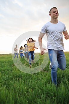 Group of people running in the grass,