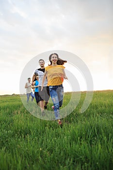 Group of people running in the grass,