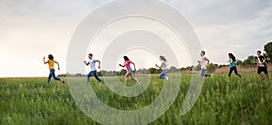 Group of people running in the grass,