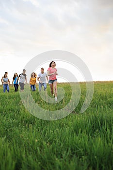 Group of people running in the grass,