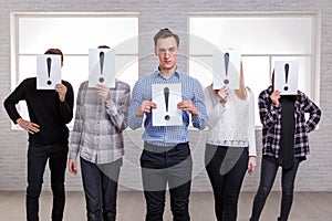 A group of people with sheets with an exclamation point