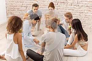 Group of young multi-ethnic beautiful couples sitting together and smiling talking eating