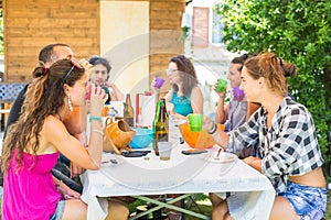 Group of people sitting having lunch together and drinking