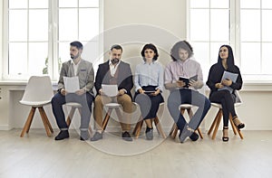 Group of people sitting in office waiting for job interview or business appointment