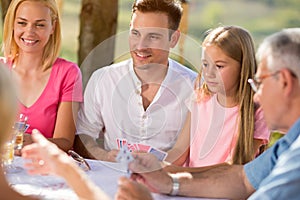 Group of people sitting and playing cards