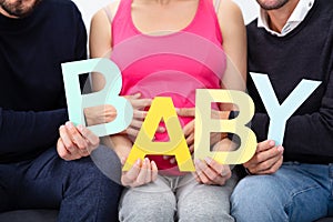 Group Of People Sitting Together Holding Alphabet Of Word Baby