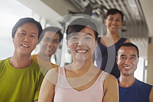 Group of people smiling and exercising in the gym, portrait