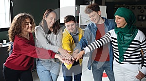 Group of people stacking hands together in community center, inclusivity and unity concept.