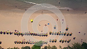 A group of people are standing on a beach near the ocean