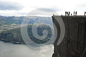 Group of people standing on the edge of a cliff in Preikestolen, Norway