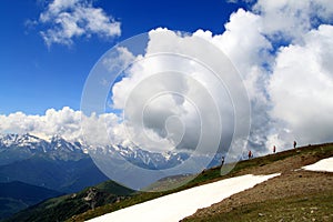 Group of people standing symmetrically on top of the ridge