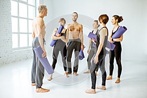 Group of people standing together after the yoga training indoors