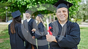 Group of people students graduated holding diploma standing with arms crossed gesture at university campus