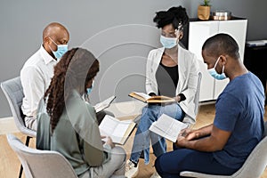 Group Of People Study Religious Book With Preacher