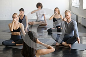 Group of people in Sukhasana, making nadi shodhana pranayama