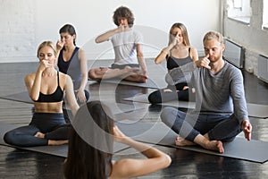 Group of people in Sukhasana pose making nadi shodhana pranayama