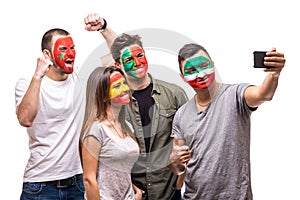 Group of people supporters fans of national teams painted flag face of Portugal, Spain, Marocco, Iran take selfie from phone. Fans