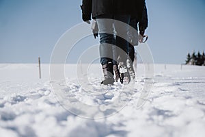 Group of people take a walk through frosty scenic winter field