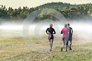 Group of people trail running outdoors in nature