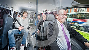 Group of people, travelling in a minivan with a busdriver and di
