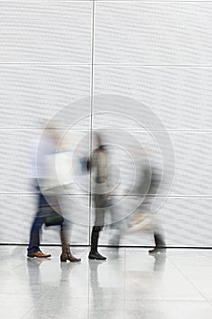 Group of people walking against white wall