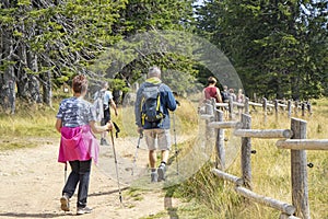 Group of people walking by hiking trail, in Rogla