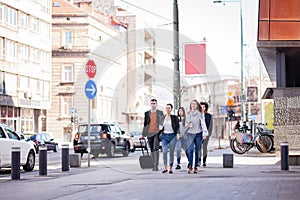 Group of people walking on a street with confidence. Businessmen and businesswomen traveling together