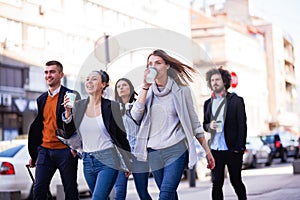 Group of people walking on a street with confidence. Businessmen and businesswomen traveling together