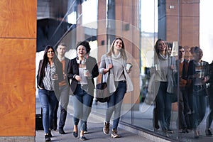 Group of people walking on a street with confidence. Businessmen and businesswomen traveling together