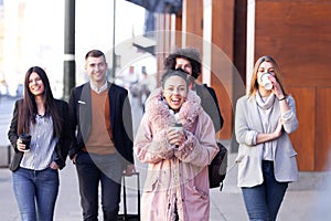 Group of people walking on a street with confidence. Businessmen and businesswomen traveling together