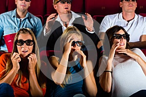 Group of people watching 3d movie at movie theater