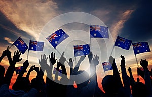 Group of People Waving Australian Flags in Back Lit