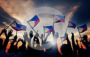 Group of People Waving Filipino Flags in Back Lit