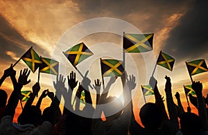 Group of People Waving Flag of Jamaica in Back Lit