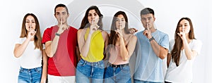 Group of people wearing casual clothes standing over isolated background asking to be quiet with finger on lips