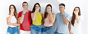 Group of people wearing casual clothes standing over isolated background bored yawning tired covering mouth with hand