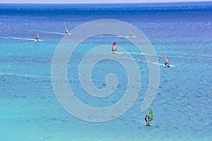 A group of people are windsurfing in the ocean