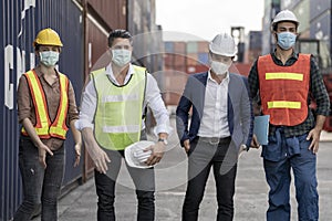 Group people worker is wearing protection mask face and safety helmet and wearing suit safety dress With background of container