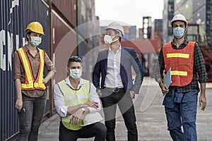 Group people worker is wearing protection mask face and safety helmet and wearing suit safety dress With background of container