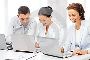 Group of people working with laptops in office