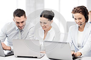 Group of people working with laptops in office