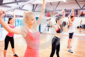 Group of people working out with barbells in gym