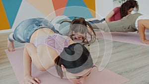 Group of people youth exercising in yoga studio stretching body on mats