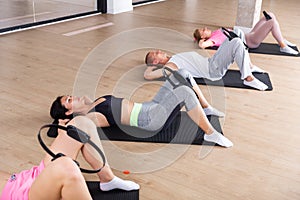 Group of peple exercising with pilates ring