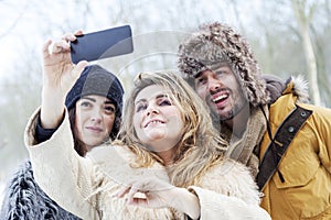 Group of person taking selfie in winter forest