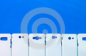 A group of phone cases on vivid blue background. Mobile cases or smartphone protector for your design