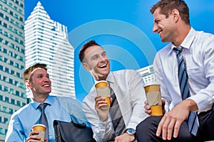 Group photo of colleagues sitting and talking while drinking coffee after work
