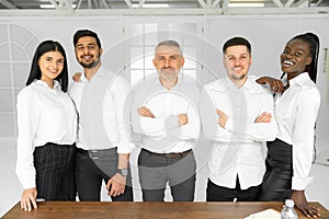 Group picture of happy diverse multiethnic young businesspeople in white shirts posing together at workplace in office