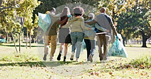 Group, plastic bag or people in park walking for waste management or recycling in community service. Back view, teamwork