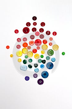 Group of plastic colorful buttons on white background. Rainbow colors red, orange, yellow, green and blue tailor texture